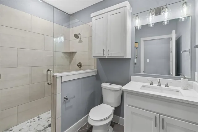 a bathroom with a sink a toilet and shower