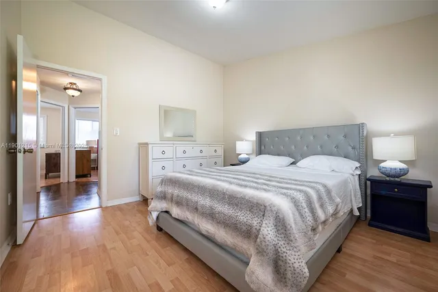 a bedroom with a bed and wooden floor