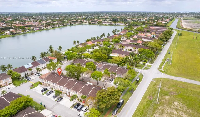 an aerial view of lake and residential houses with outdoor space