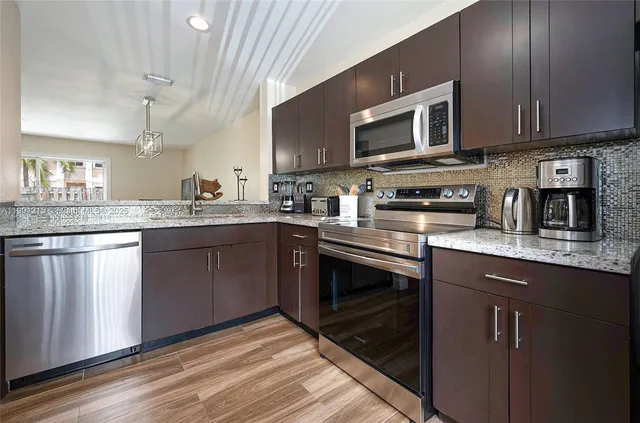 a kitchen with stainless steel appliances granite countertop a sink stove and microwave