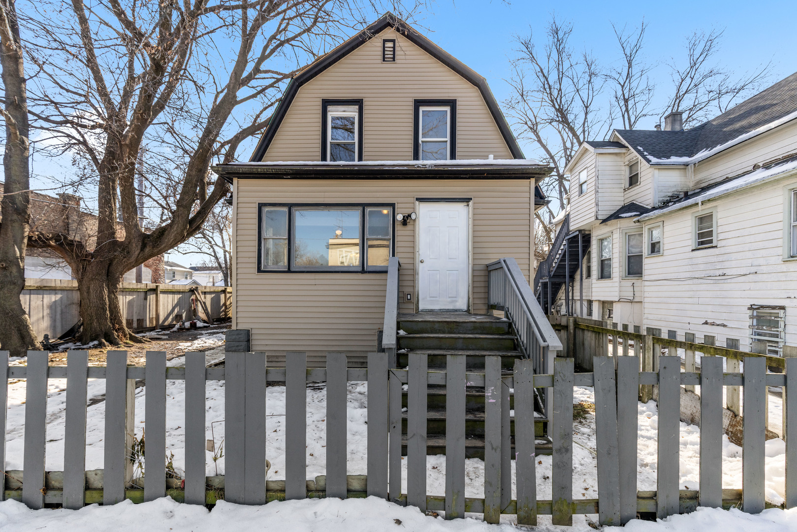 a front view of a house with a tree