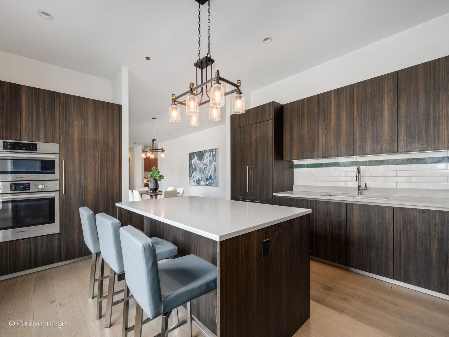 305 South Racine Avenue, Unit 2A Chicago, IL 60607 - Photo 10 of 29 a kitchen with a sink a stove a refrigerator and island with wooden floor