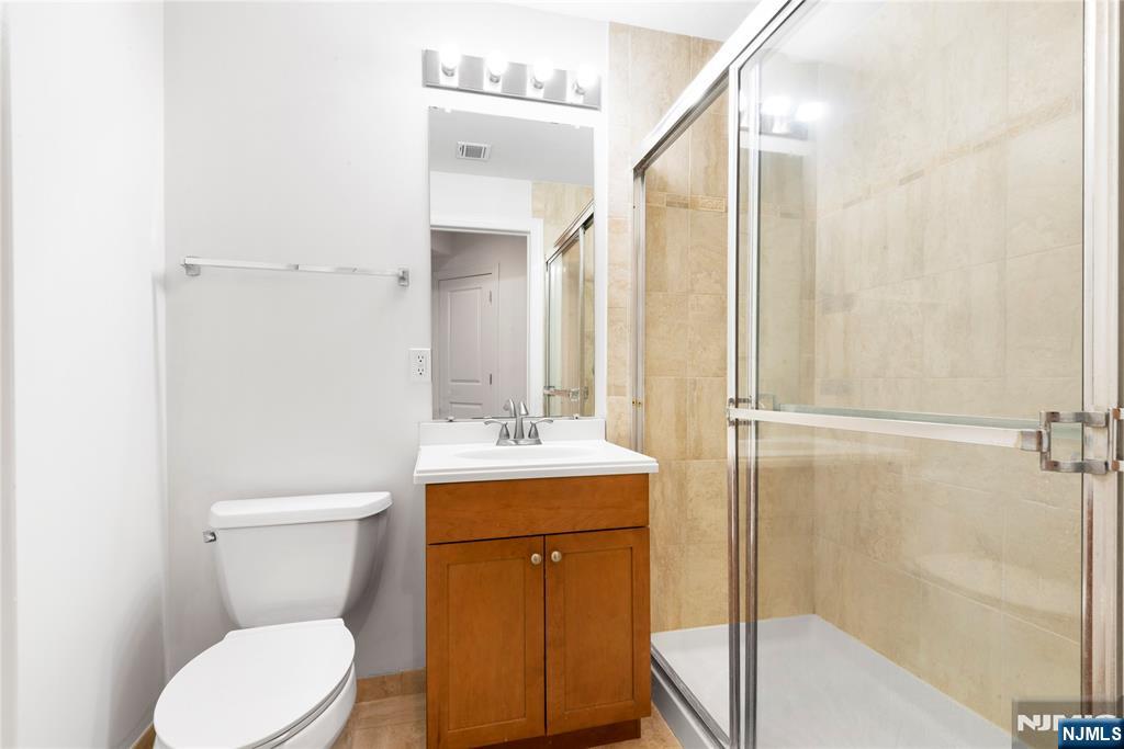 54 Polifly Road, Unit 311 Hackensack, NJ 07601 - Photo 19 of 20 a bathroom with a toilet a sink and bathtub