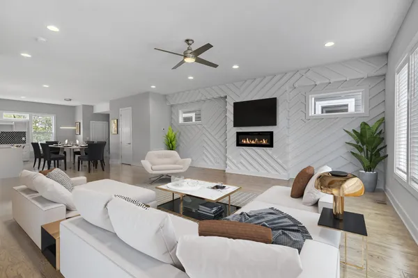 an empty room with wooden floor ceiling fan and windows