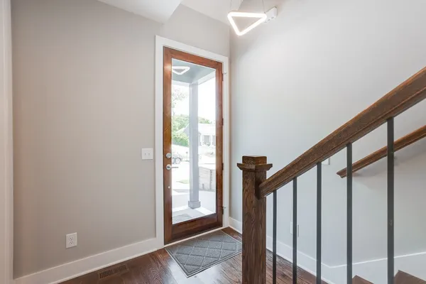 a view of staircase with wooden floor and white walls
