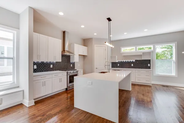 a kitchen with stove a sink dishwasher and a refrigerator