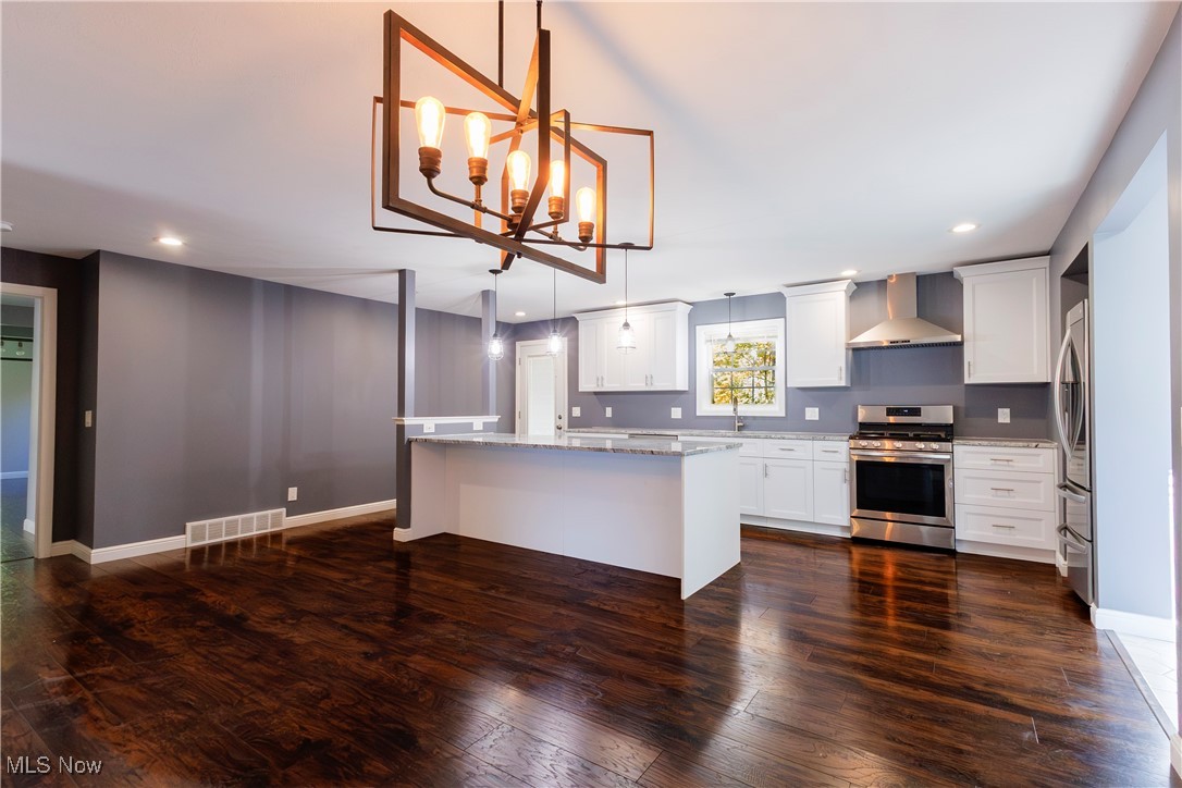 36625 Jackson Road Chagrin Falls, OH 44022 - Photo 24 of 50 Kitchen with a center island, stainless steel appliances, wall chimney exhaust hood, pendant lighting, and white cabinets