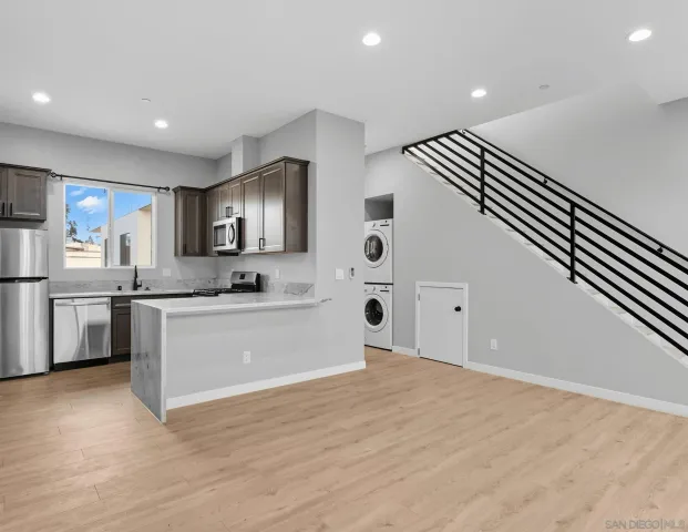 a kitchen with stainless steel appliances granite countertop a sink stove microwave and refrigerator