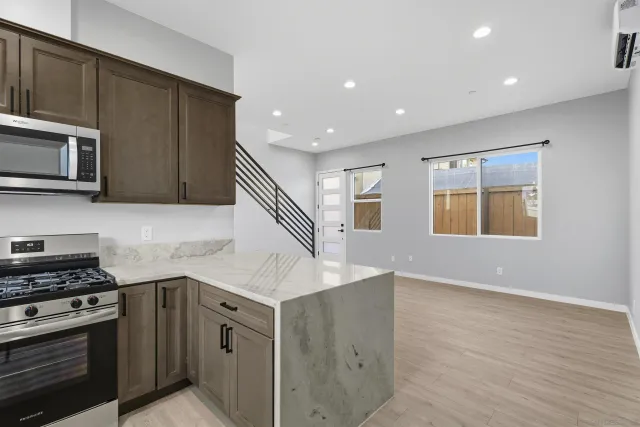 a living room with stainless steel appliances kitchen island granite countertop furniture and a kitchen view