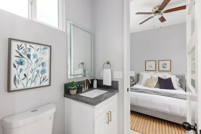 a bathroom with a granite countertop sink a mirror and shower