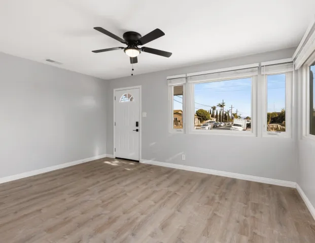 a view of empty room with wooden floor and fireplace