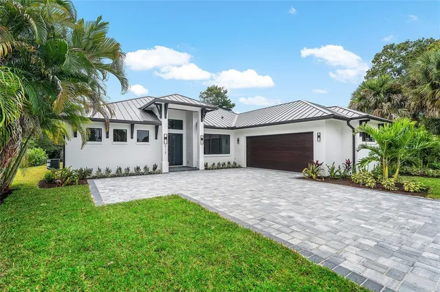a front view of a house with a garden and yard