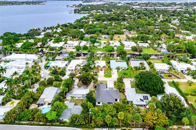 an aerial view of residential houses with outdoor space and trees all around