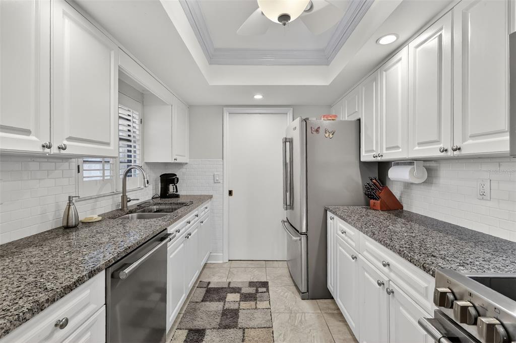 100 South Tremain Street, Unit F1 Mount Dora, FL 32757 - Photo 6 of 47 a kitchen with stainless steel appliances granite countertop a sink stove and refrigerator