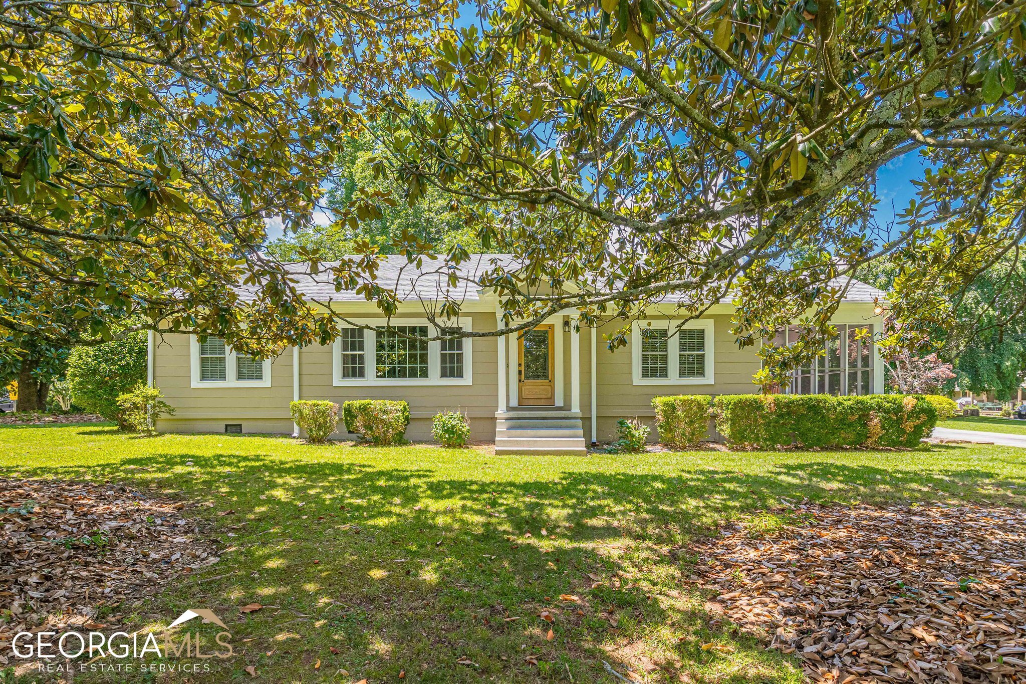 a view of a house with a big yard and large trees