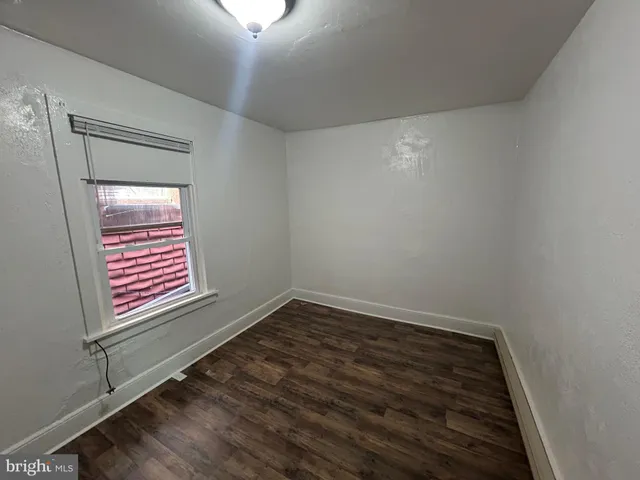 a view of a hallway with wooden floor and a window