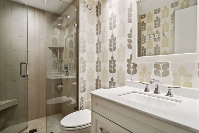 a bathroom with a sink toilet vanity and shower
