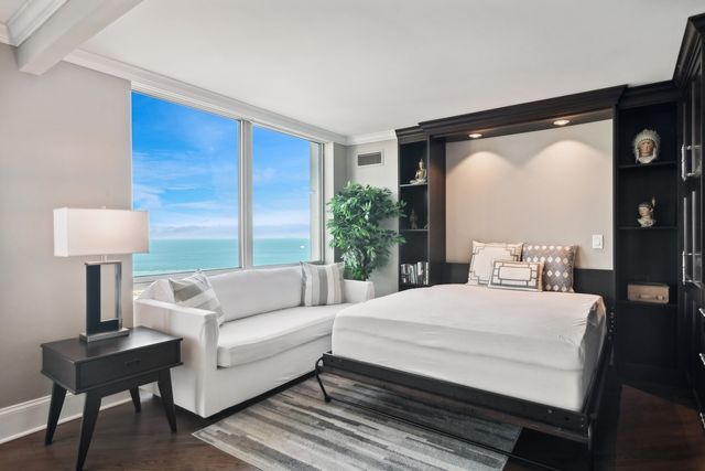 a bedroom with a bed a lamp and a large window