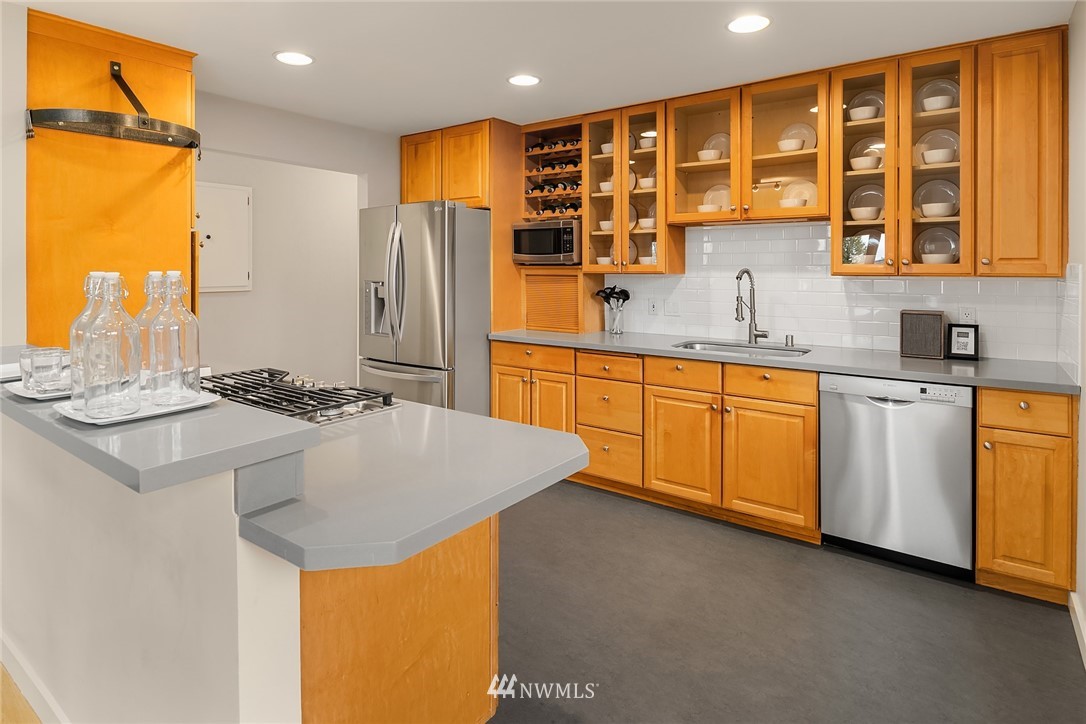 8750 Fauntlee Crest Southwest Seattle, WA 98136 - Photo 14 of 40 a kitchen with stainless steel appliances granite countertop a sink and cabinets