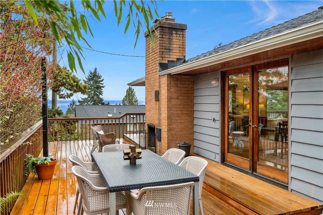 8750 Fauntlee Crest Southwest Seattle, WA 98136 - Photo 32 of 40 a view of deck with a table and chairs and wooden floor