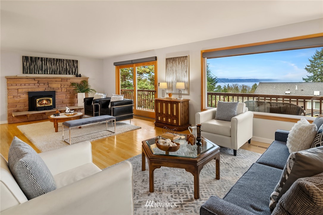 8750 Fauntlee Crest Southwest Seattle, WA 98136 - Photo 7 of 40 a living room with furniture a fireplace and a floor to ceiling window