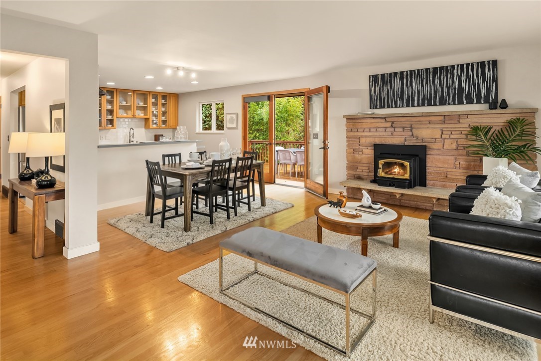 8750 Fauntlee Crest Southwest Seattle, WA 98136 - Photo 9 of 40 a living room with furniture a fireplace and a dining table with wooden floor