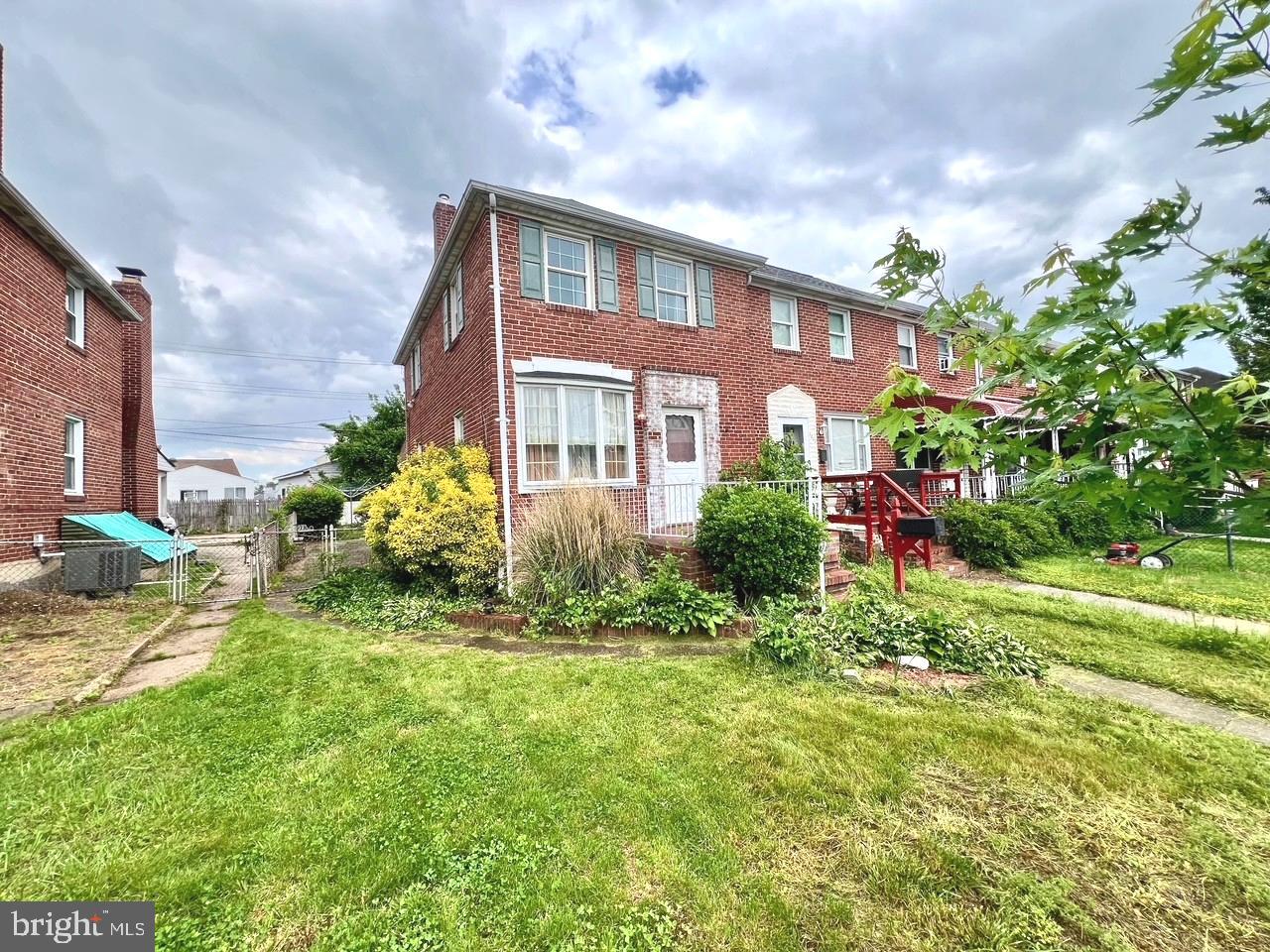 a front view of a house with a yard and potted plants