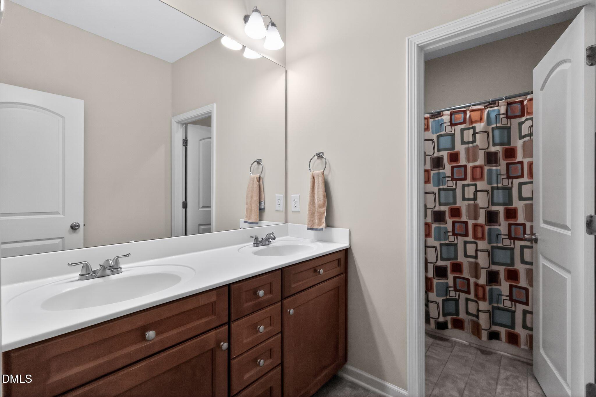 3428 Massey Pond Trail Raleigh, NC 27616 - Photo 28 of 39 a bathroom with a double vanity sink a and a mirror