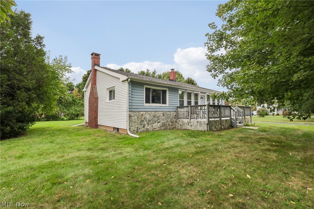 4188 Manchester Road Perry, OH 44081 - Photo 2 of 41 Light blue siding exterior with a stone foundation, a brick chimney, and a wooden deck