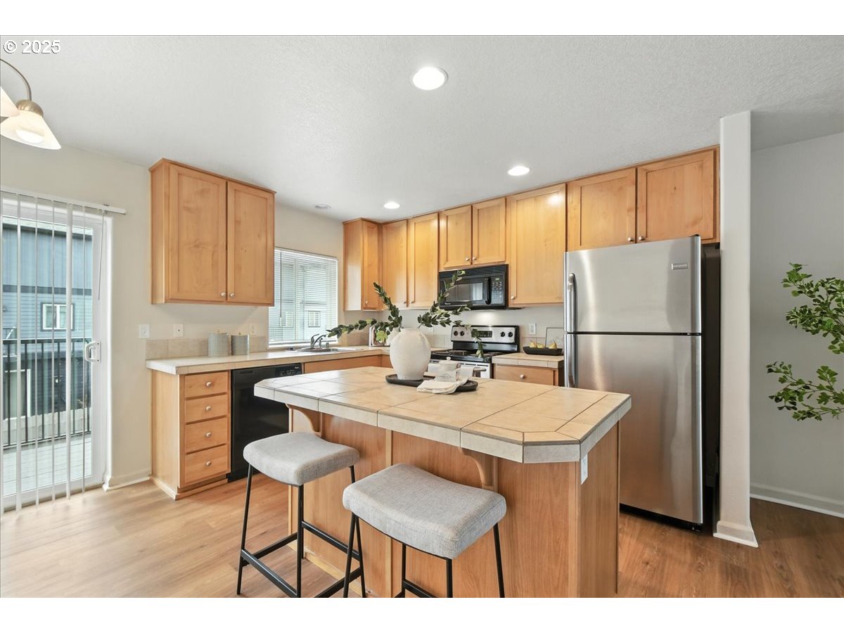 5927 Northeast 34th Street Vancouver, WA 98661 - Photo 7 of 29 a kitchen with a refrigerator a stove a sink dishwasher with a dining table and chair