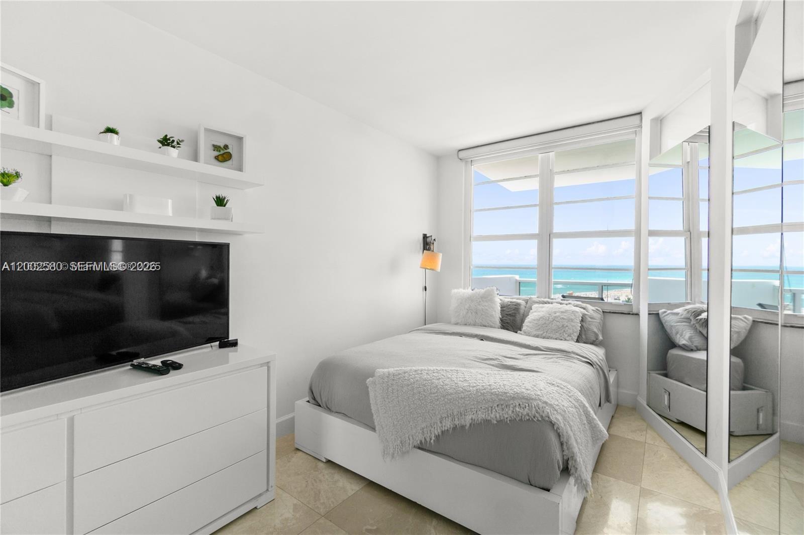 100 Lincoln Road, Unit 1046 Miami Beach, FL 33139 - Photo 11 of 18 a bedroom with a bed a flat tv and a large window