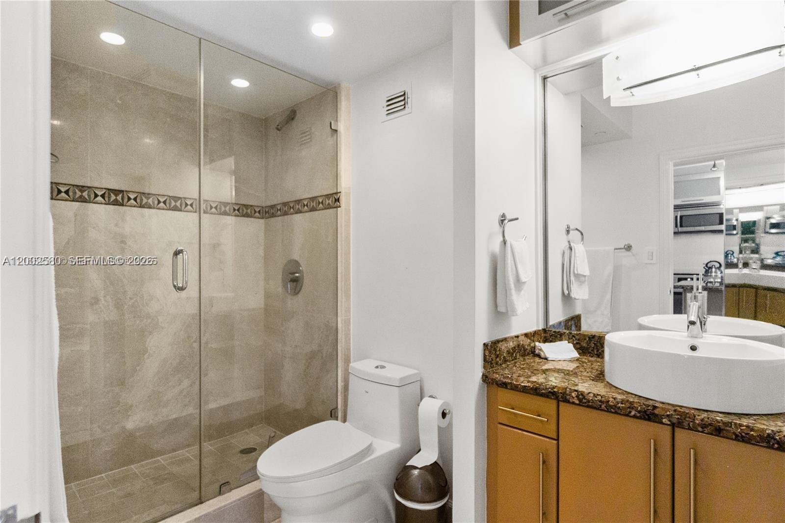 100 Lincoln Road, Unit 1046 Miami Beach, FL 33139 - Photo 14 of 18 a bathroom with a granite countertop sink a toilet and shower