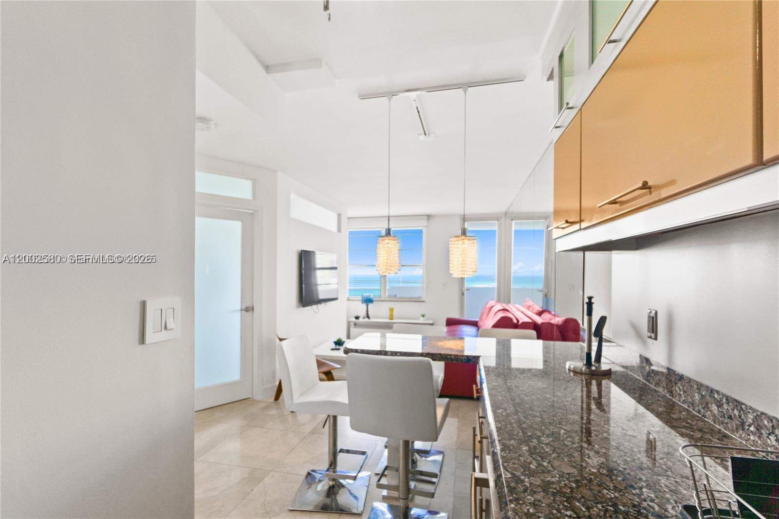 100 Lincoln Road, Unit 1046 Miami Beach, FL 33139 - Photo 5 of 18 a view of a dining room with furniture one side kitchen view and wooden floor