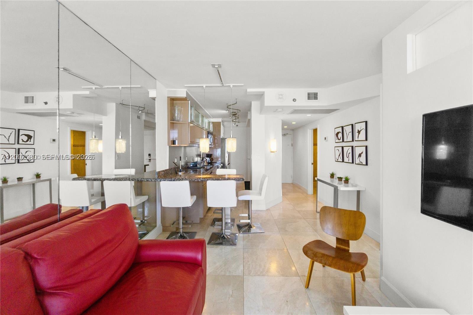 100 Lincoln Road, Unit 1046 Miami Beach, FL 33139 - Photo 6 of 18 a living room with furniture a flat screen tv and kitchen view