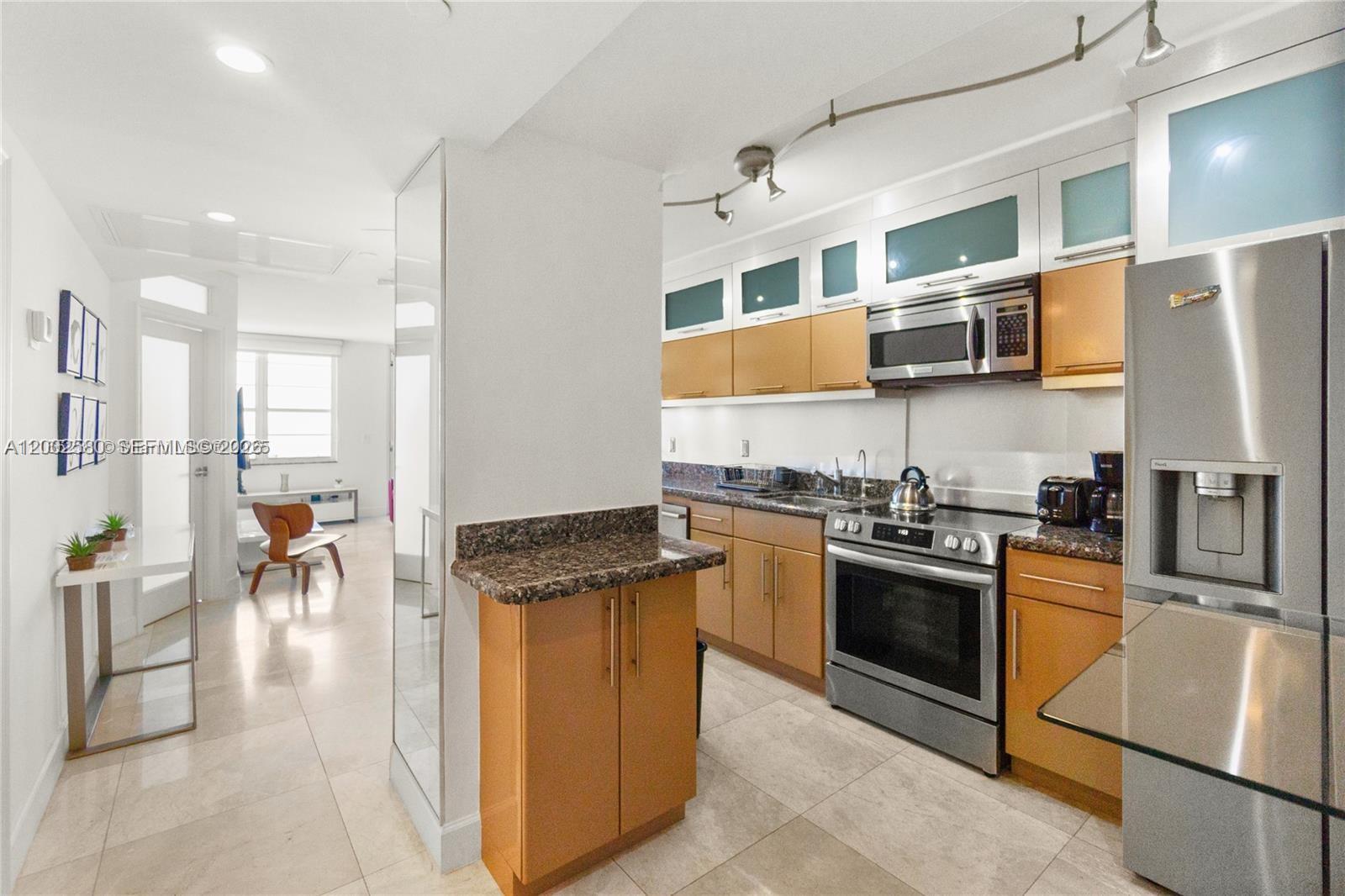 100 Lincoln Road, Unit 1046 Miami Beach, FL 33139 - Photo 9 of 18 a kitchen with stainless steel appliances granite countertop a stove and a refrigerator