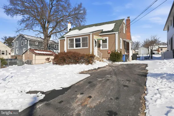 a front view of a house with a yard covered in snow