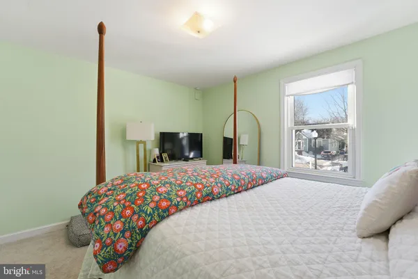 a bedroom with a bed and a painting on the wall