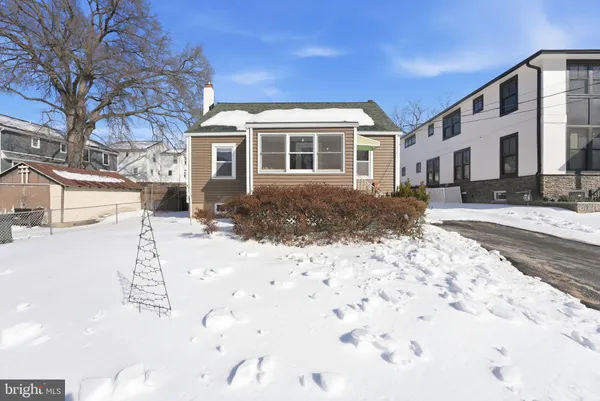 a front view of a house with a yard covered in snow
