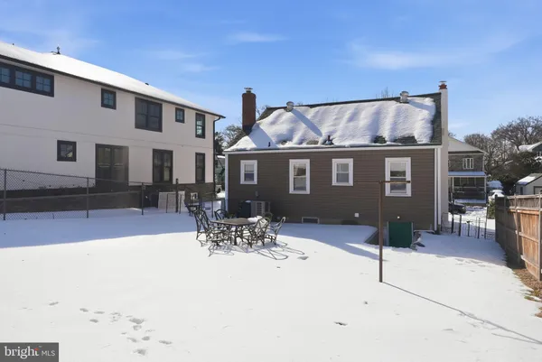 a patio with table and chairs and potted plants