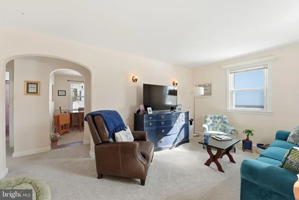 a living room with furniture a flat screen tv and a window