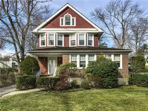 Front exterior with porch and side driveway.