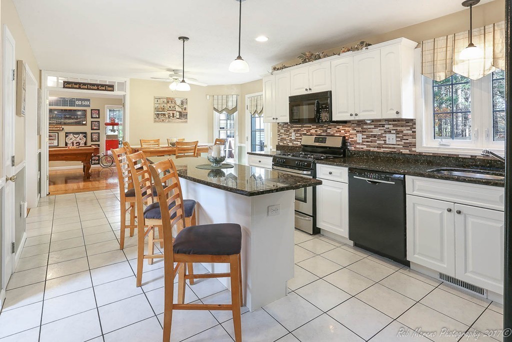 9 Garrison Road Dracut, MA 01826 - Photo 8 of 30 a kitchen with stainless steel appliances granite countertop a stove a sink a microwave and a refrigerator