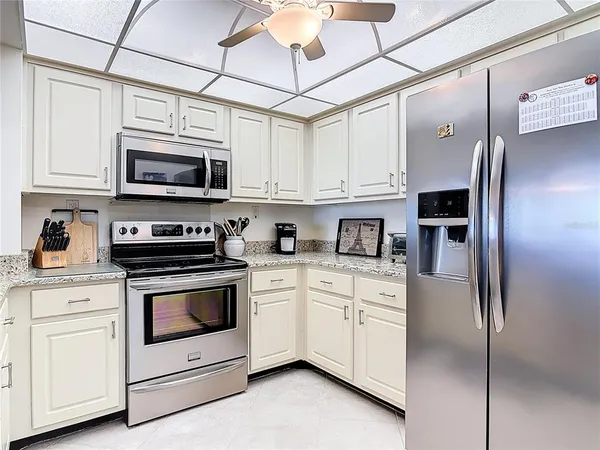 a kitchen with white cabinets and appliances