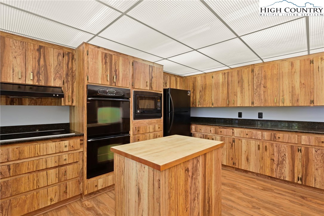 202 Cliffside Lane Seven Devils, NC 28604 - Photo 13 of 46 a kitchen with stainless steel appliances kitchen island granite countertop a refrigerator a stove and a sink