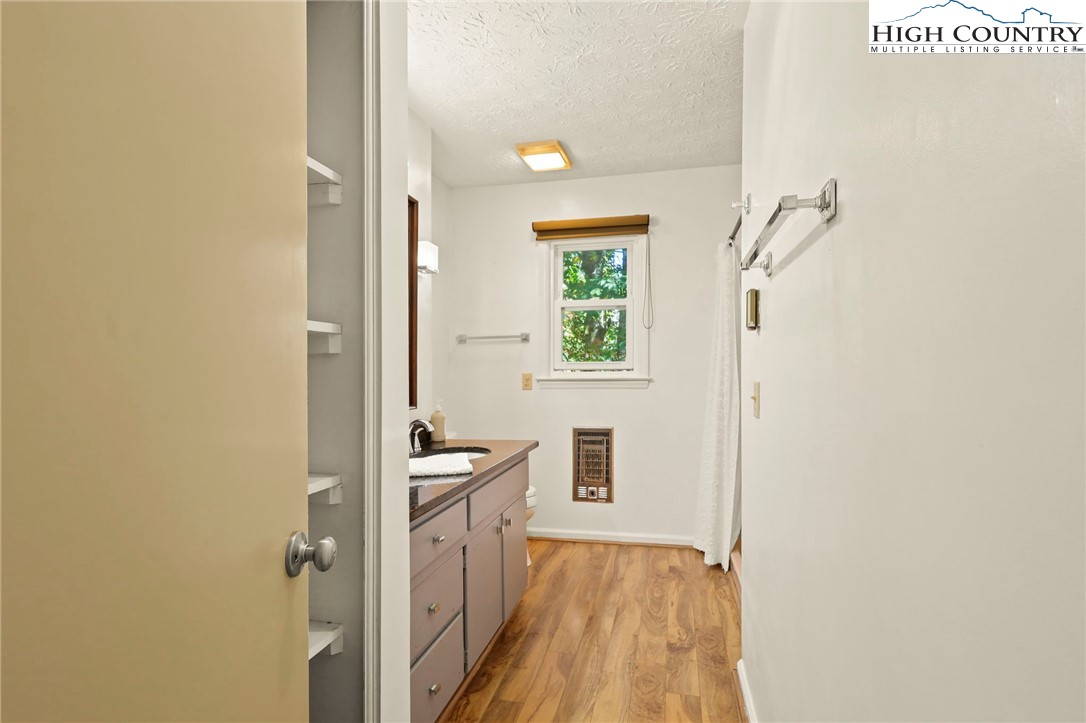 202 Cliffside Lane Seven Devils, NC 28604 - Photo 22 of 46 a view of a hallway with wooden floor and a bathroom
