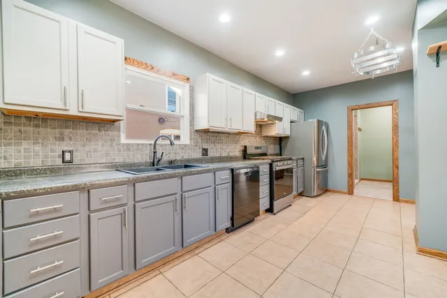 a kitchen with granite countertop a sink stainless steel appliances and cabinets