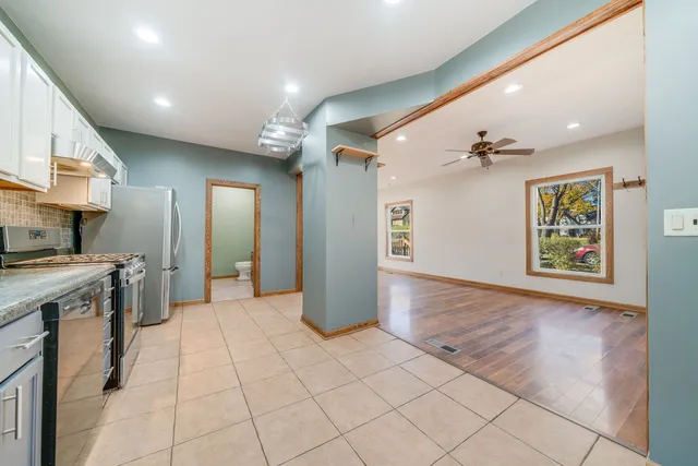 a view of a kitchen with stainless steel appliances granite countertop a refrigerator and a sink