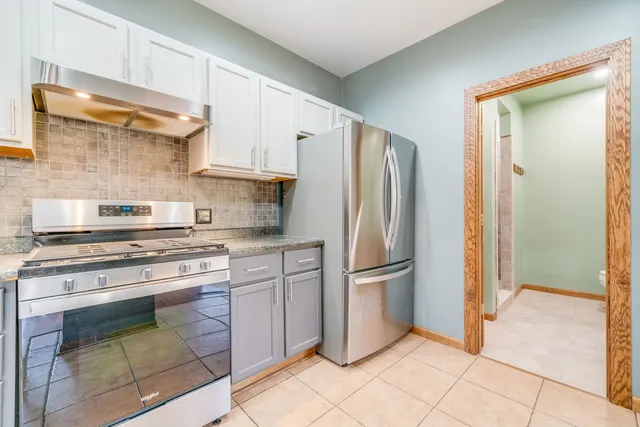 a kitchen with stainless steel appliances granite countertop a refrigerator and a stove top oven