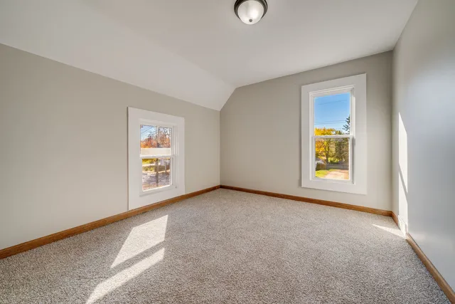 an empty room with window and fireplace