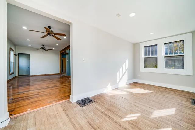 a view of a room with wooden floor and a ceiling fan